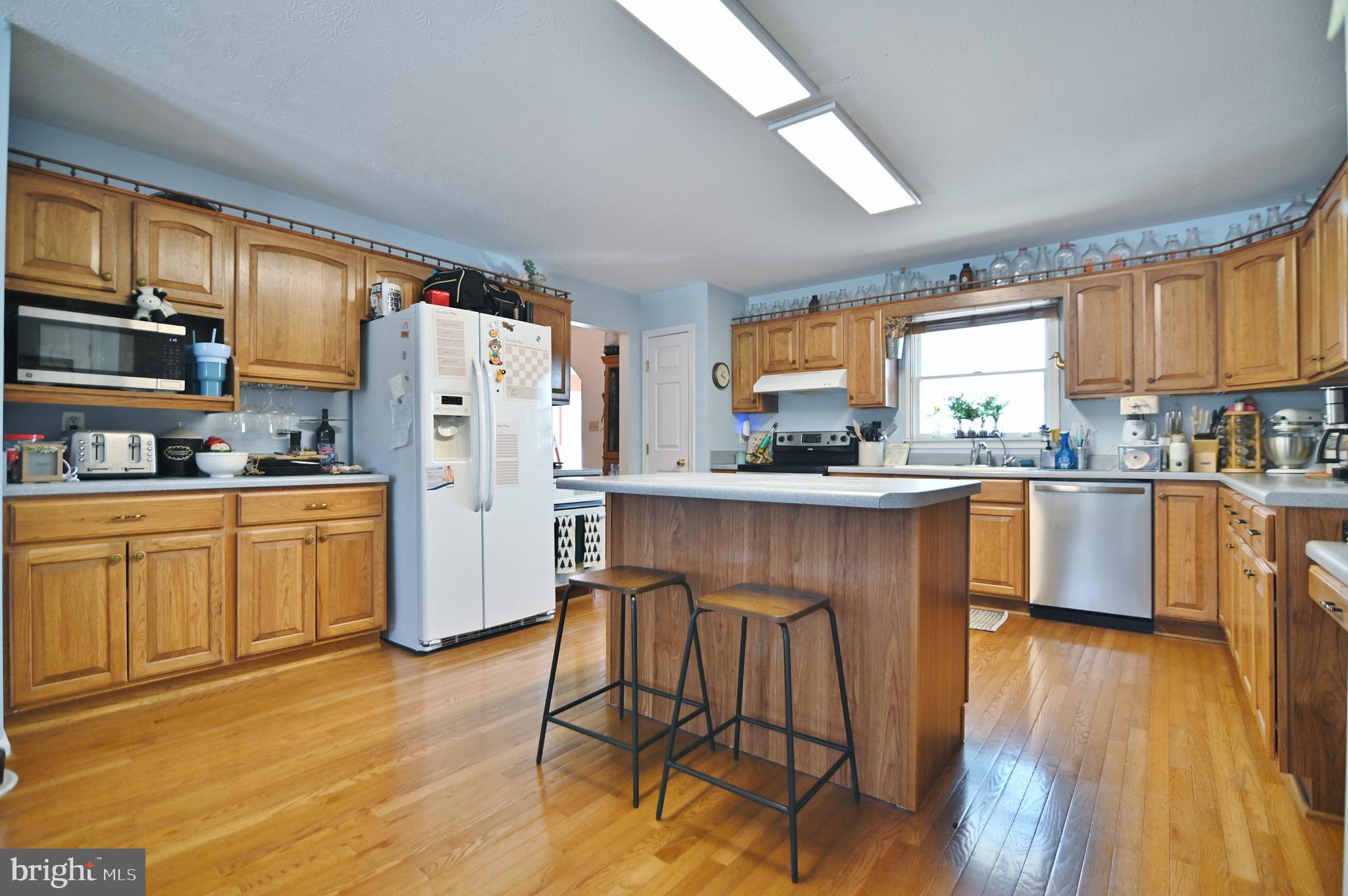 8284 Back Road Maurertown, VA 22644 - Photo 28 of 54 a kitchen with granite countertop wooden floors white cabinets and appliances