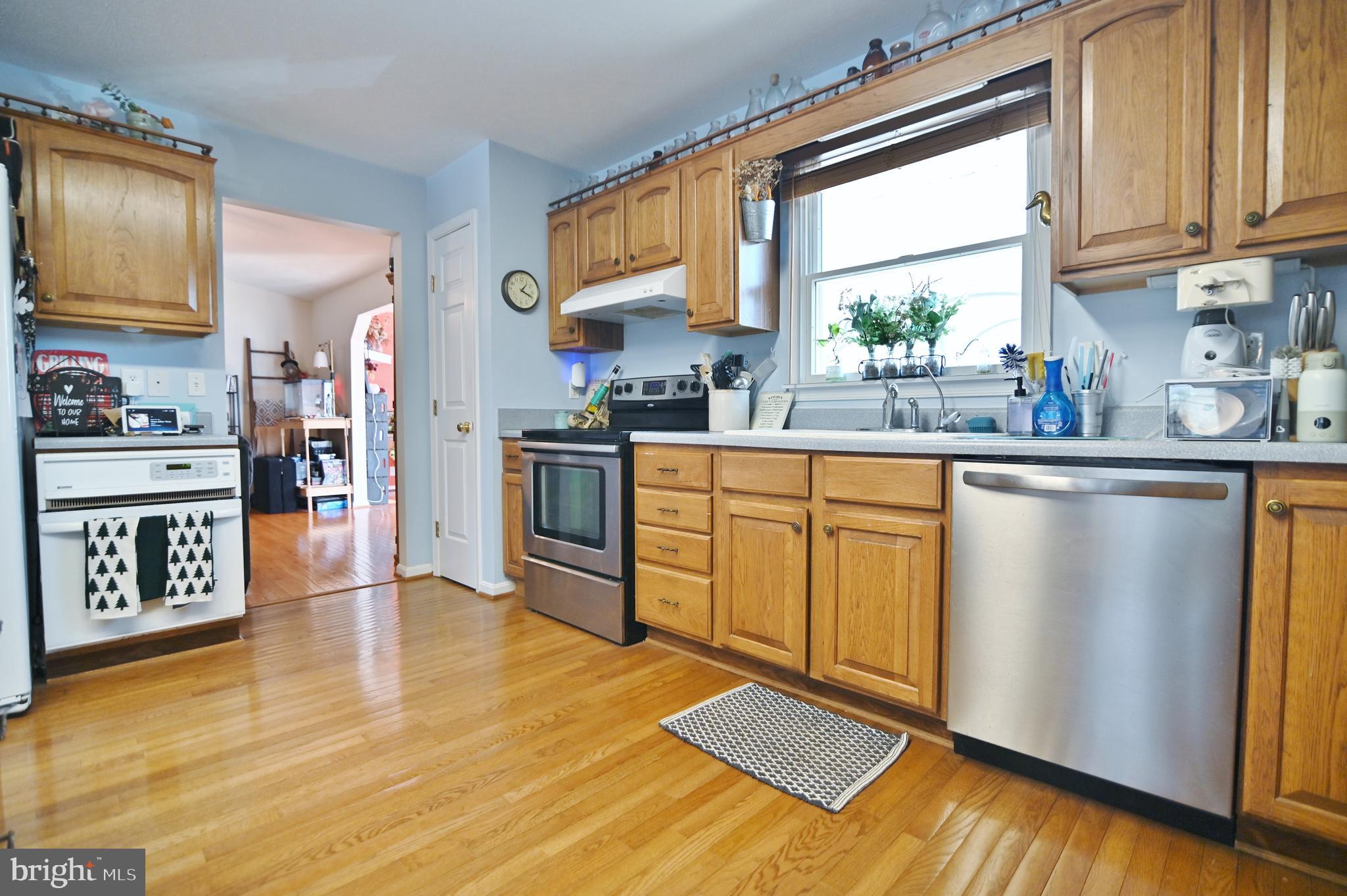 8284 Back Road Maurertown, VA 22644 - Photo 29 of 54 a kitchen with stainless steel appliances granite countertop a stove top oven a sink dishwasher and white cabinets with wooden floor