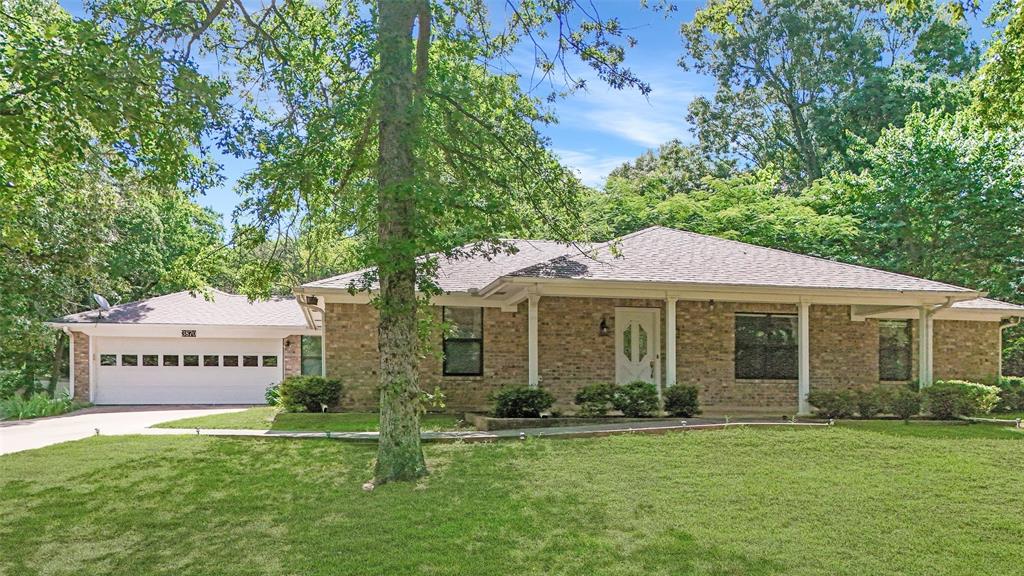 3870 County Road Arthur City, TX 75411 - Photo 1 of 39 Brick exterior residence with a covered front entry, an attached two-car garage, and a lush green lawn
