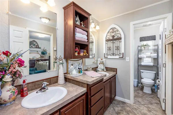 a bathroom with double vanity sinks a toilet and a mirror