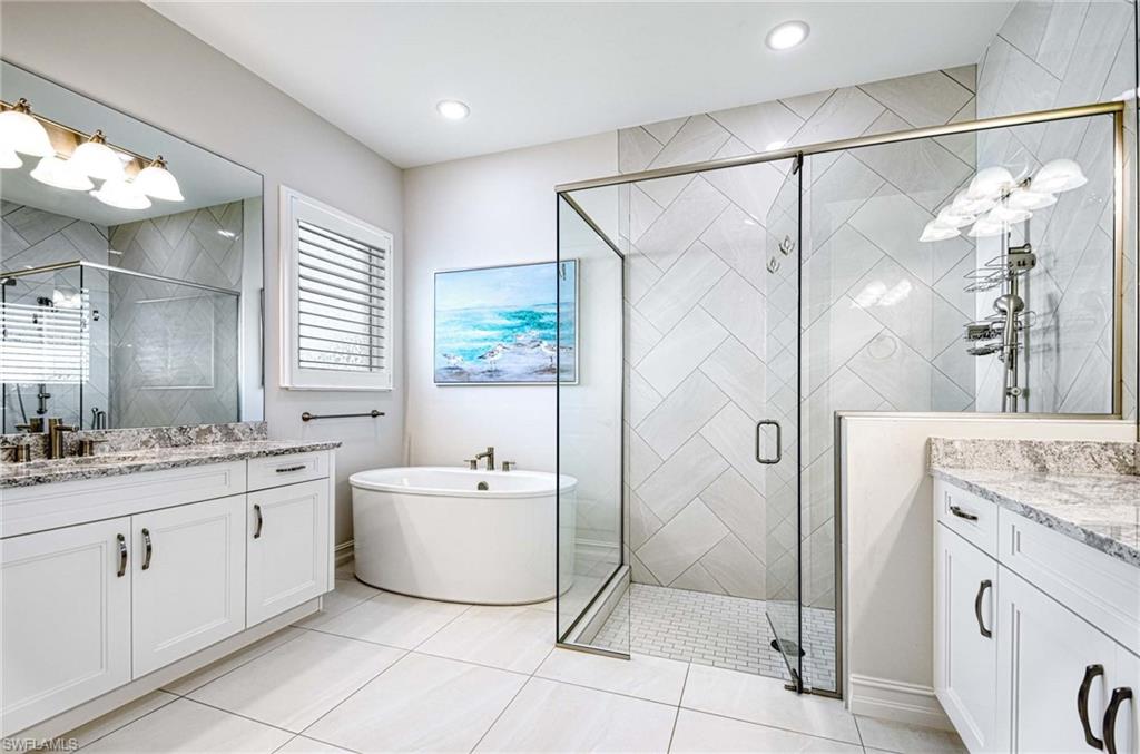 6159 Rodney Bay Lane Naples, FL 34113 - Photo 14 of 50 a spacious bathroom with a granite countertop sink a mirror and a shower
