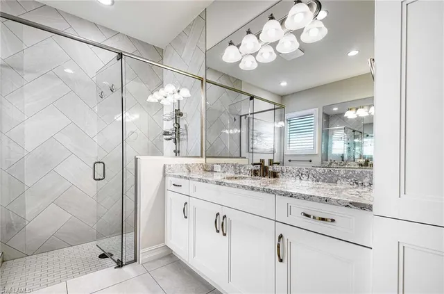 a spacious bathroom with a granite countertop sink a mirror and a shower