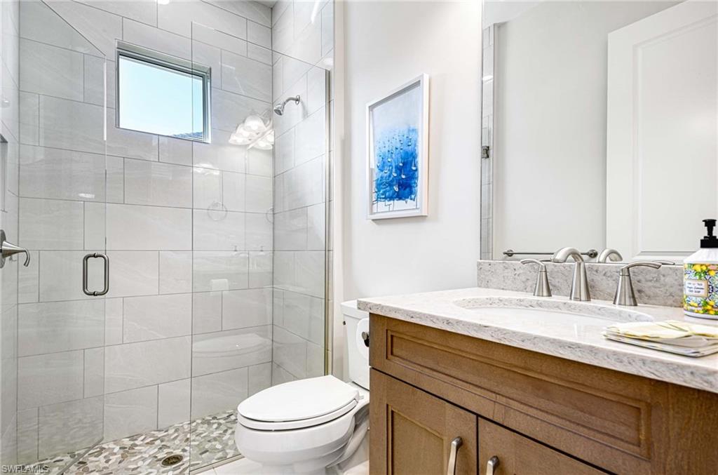 6159 Rodney Bay Lane Naples, FL 34113 - Photo 17 of 50 a bathroom with a sink a toilet and shower
