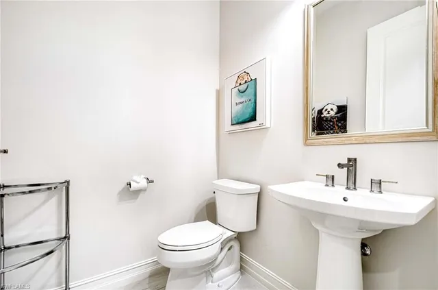 a bathroom with a toilet a sink and mirror