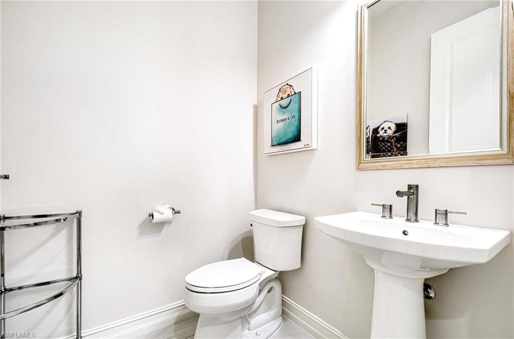 6159 Rodney Bay Lane Naples, FL 34113 - Photo 18 of 50 a bathroom with a toilet a sink and mirror