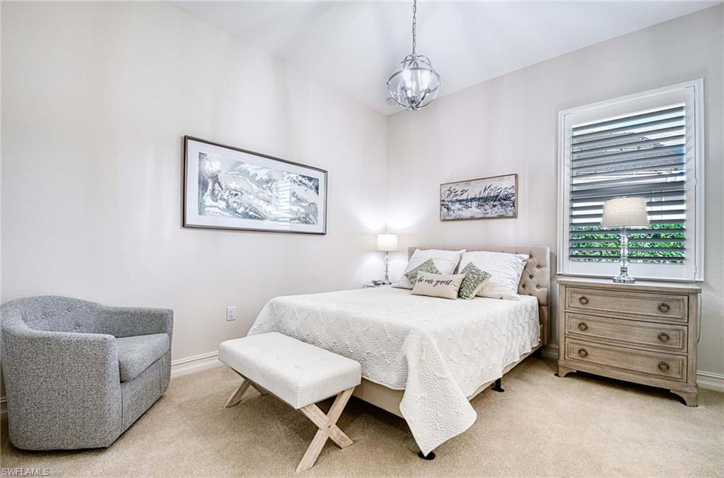 6159 Rodney Bay Lane Naples, FL 34113 - Photo 22 of 50 a bedroom with a bed a couch and a window