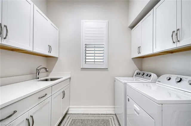 a utility room with sink dryer and washer
