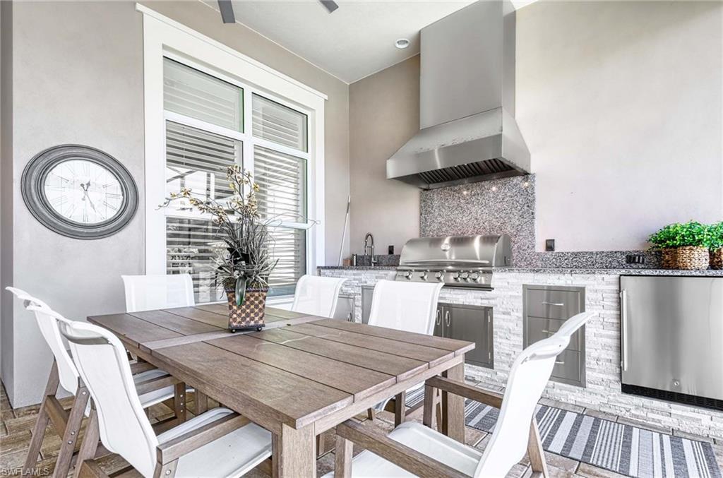 6159 Rodney Bay Lane Naples, FL 34113 - Photo 26 of 50 a dining room with furniture a large window and wooden floor
