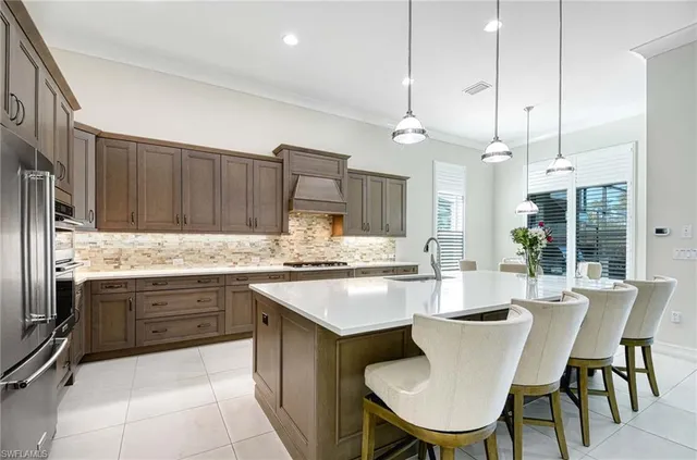 a kitchen with granite countertop a stove a sink a dining table and chairs