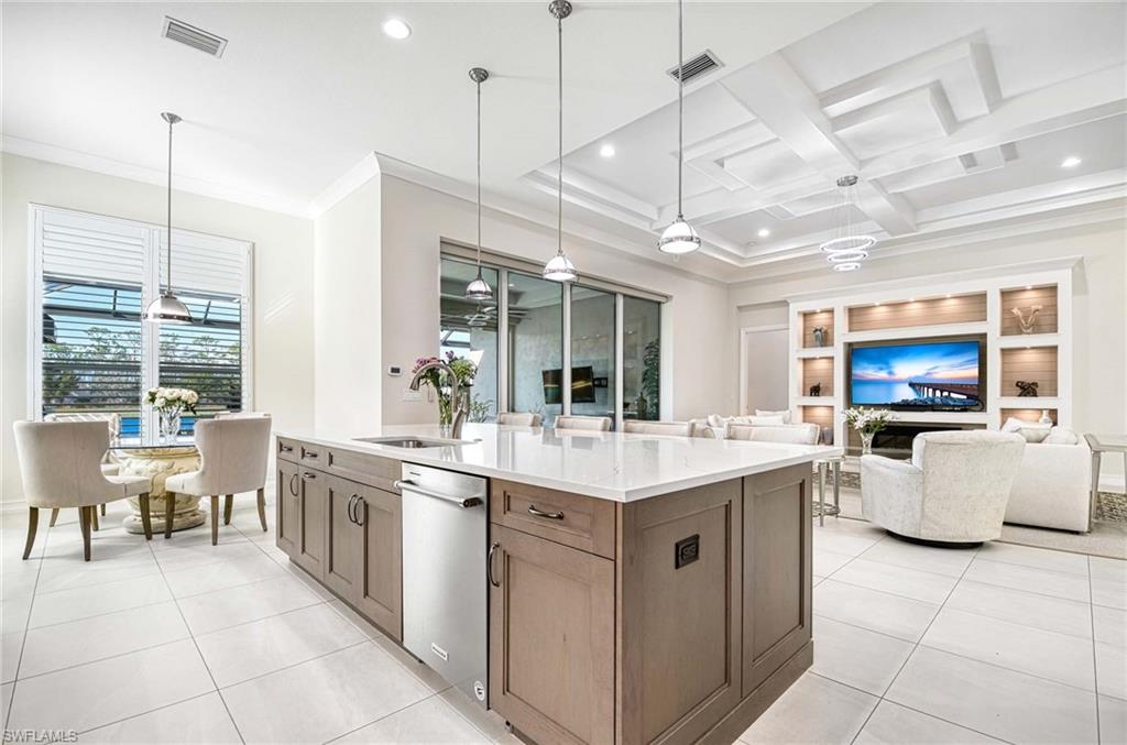 6159 Rodney Bay Lane Naples, FL 34113 - Photo 6 of 50 a view of kitchen with stainless steel appliances granite countertop center island a stove a sink a dining table and chairs
