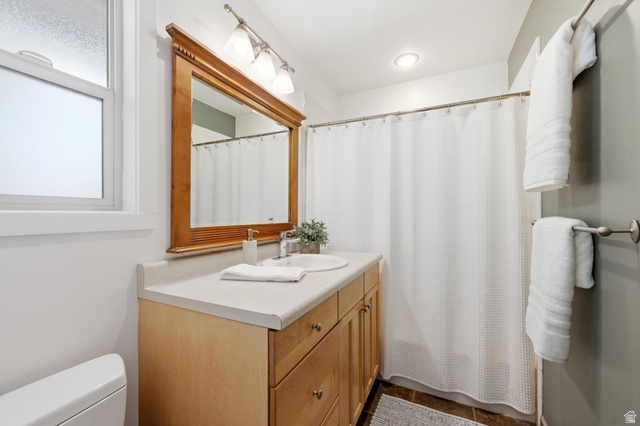 1709 Meadowmoor Road Holladay, UT 84117 - Photo 17 of 32 Wood-finish vanity with two inset sinks, stone-finish countertop, and a large wood-framed mirror