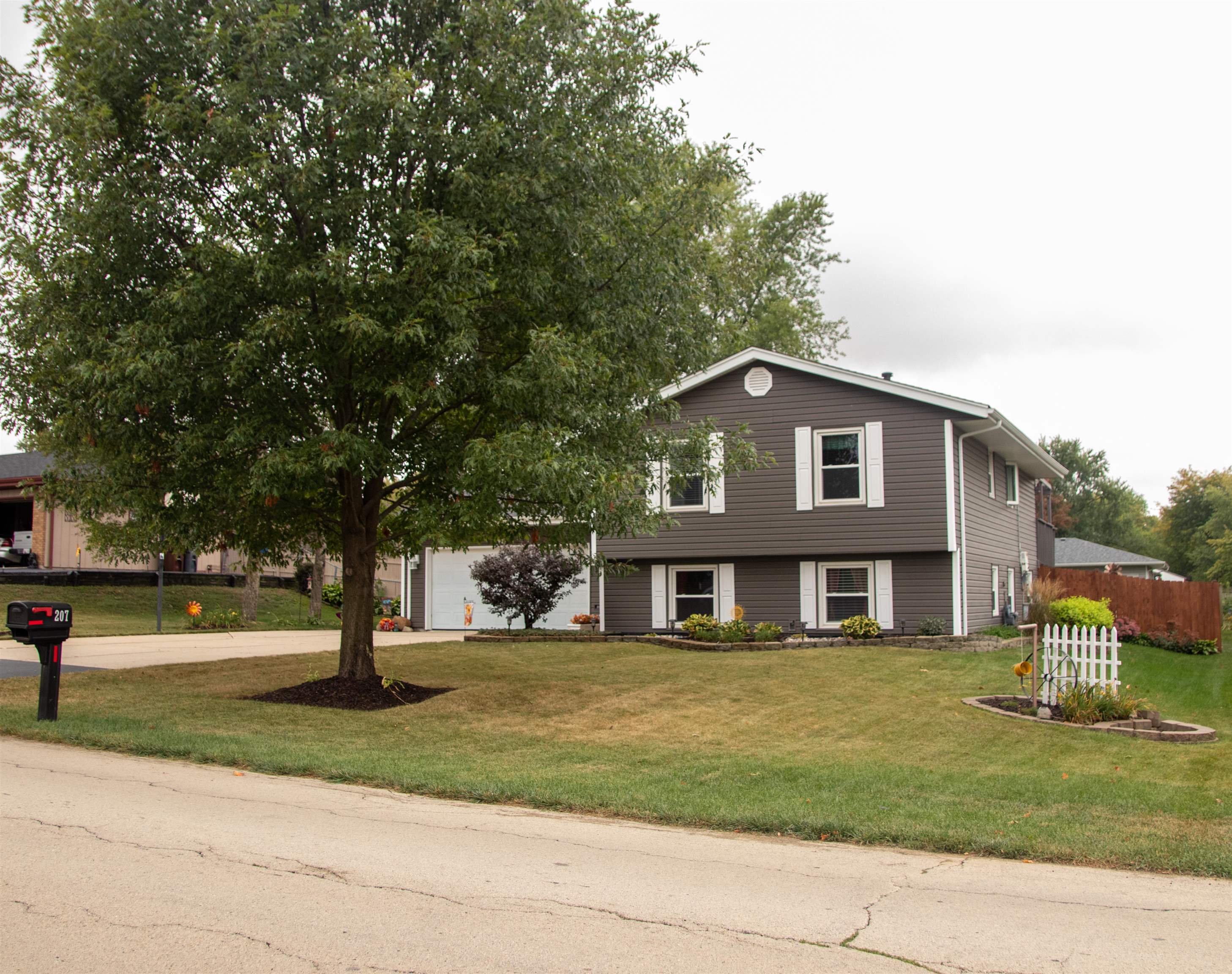207 Westfield Road Winnebago, IL 61088 - Photo 2 of 27 a front view of a house with a garden