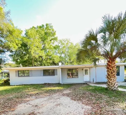 a view of a yard in front of a house with large tree