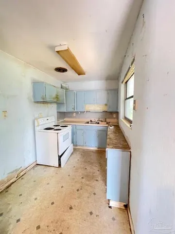 a kitchen with a sink a counter top space cabinets and appliances