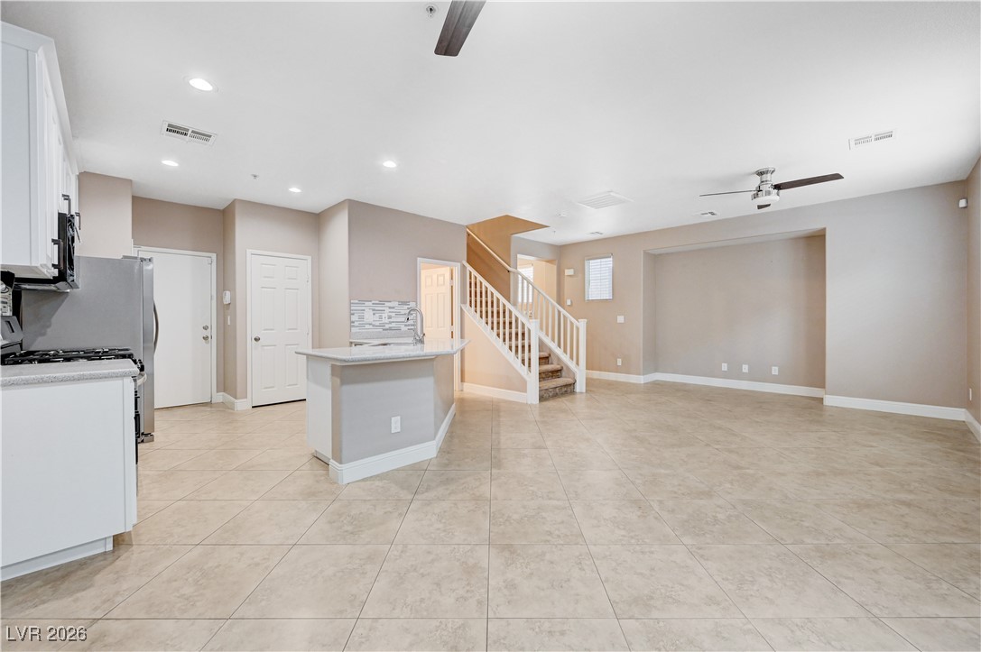 645 Monument Point Street Henderson, NV 89002 - Photo 12 of 54 Kitchen with a ceiling fan, white cabinets, backsplash, recessed lighting, and light tile patterned floors