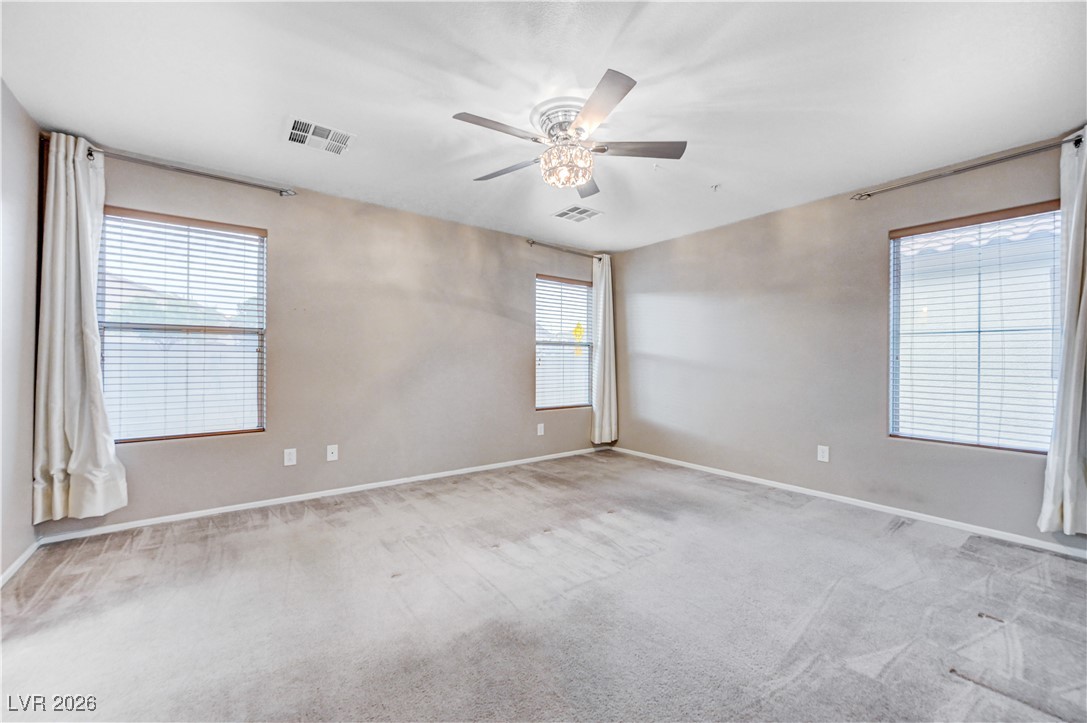 645 Monument Point Street Henderson, NV 89002 - Photo 27 of 54 Empty room with light colored carpet and a ceiling fan