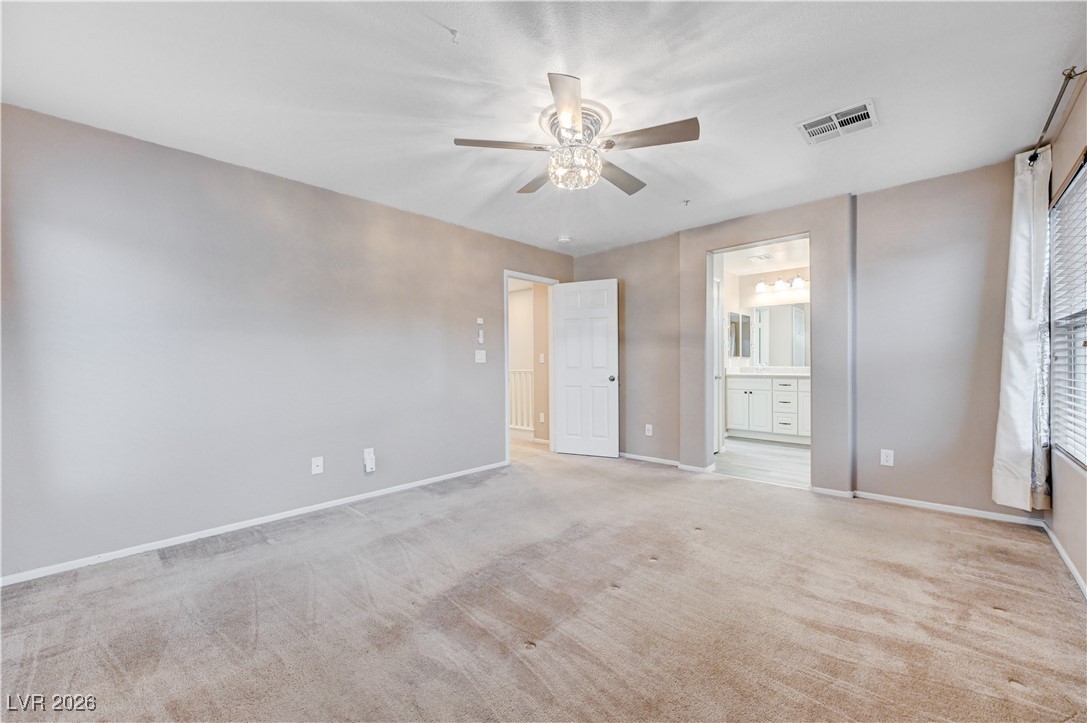 645 Monument Point Street Henderson, NV 89002 - Photo 28 of 54 Unfurnished bedroom with ceiling fan, light colored carpet, and connected bathroom