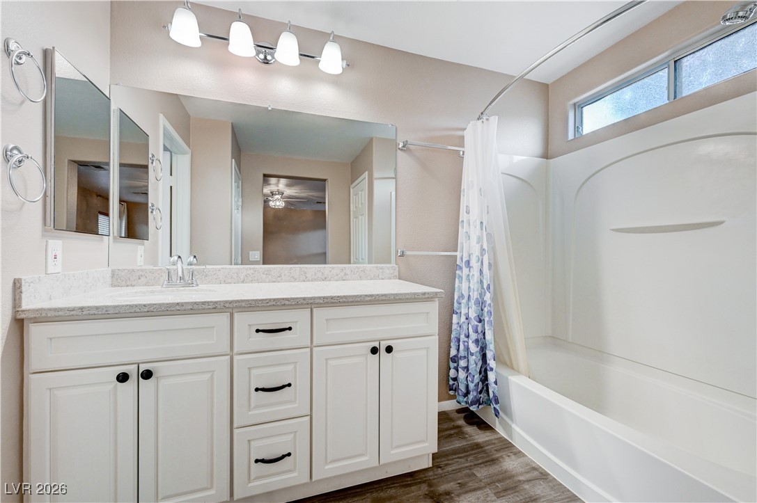 645 Monument Point Street Henderson, NV 89002 - Photo 31 of 54 Bathroom featuring shower / bath combo with shower curtain, vanity, and dark wood-type flooring