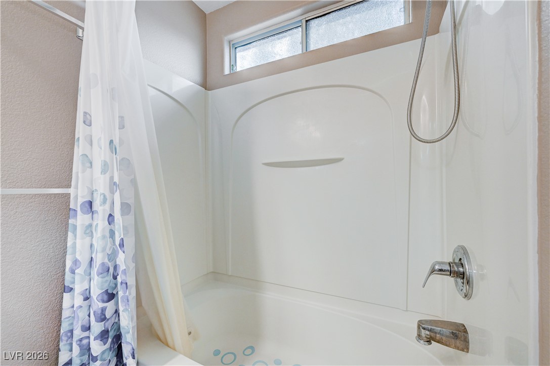 645 Monument Point Street Henderson, NV 89002 - Photo 34 of 54 Bathroom with shower / tub combo and a textured wall