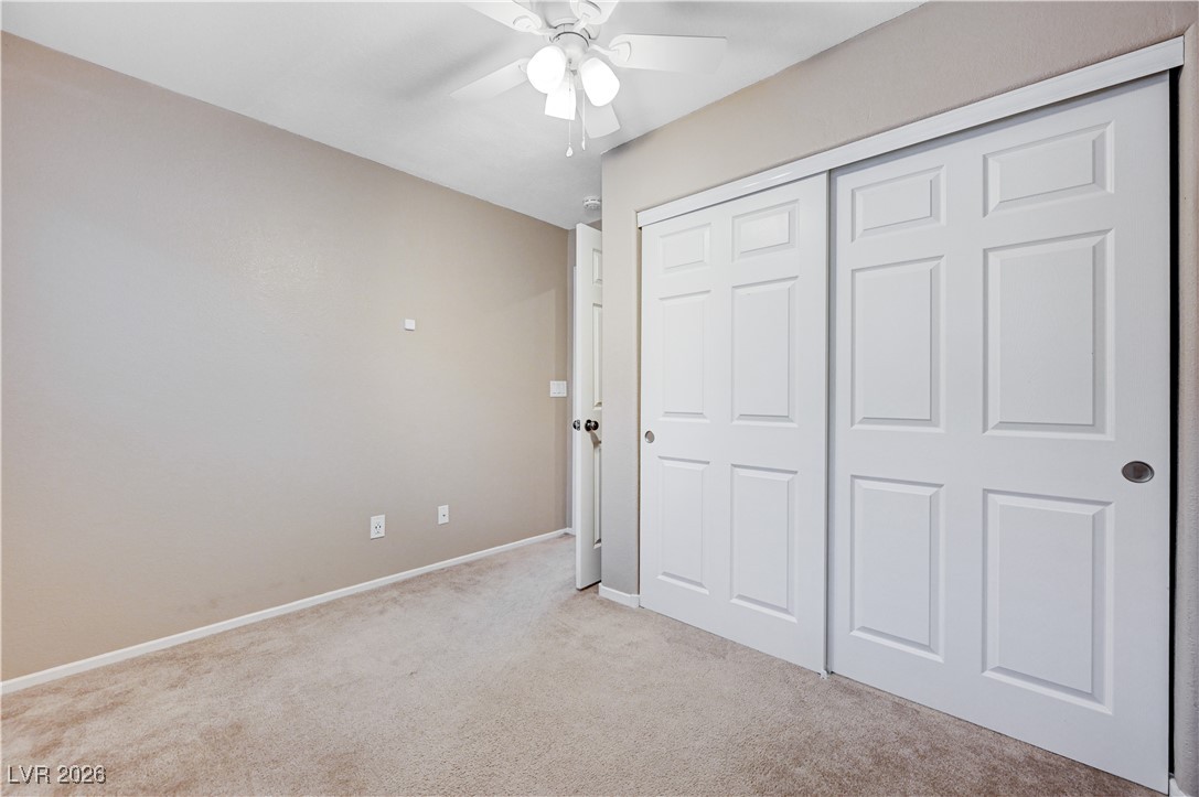 645 Monument Point Street Henderson, NV 89002 - Photo 37 of 54 Unfurnished bedroom with light colored carpet, a closet, and ceiling fan