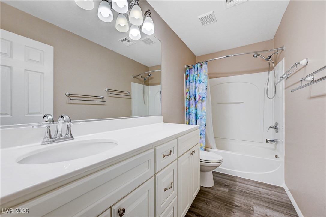 645 Monument Point Street Henderson, NV 89002 - Photo 39 of 54 Bathroom with vanity, shower / bath combo with shower curtain, and dark wood finished floors