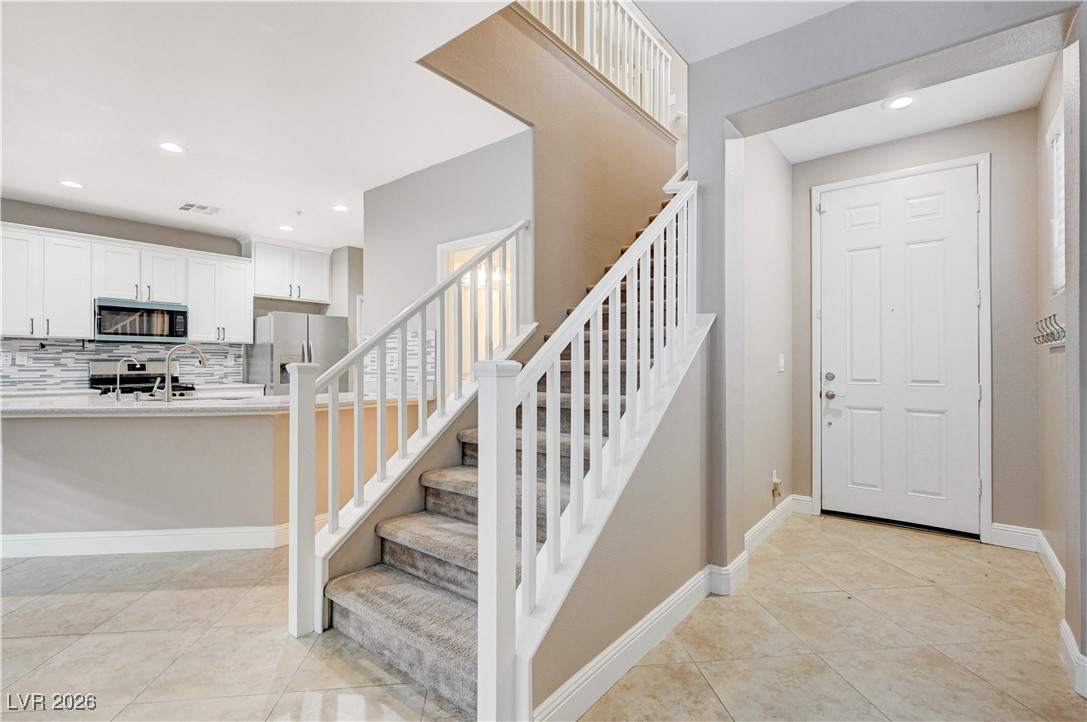 645 Monument Point Street Henderson, NV 89002 - Photo 5 of 54 Staircase with recessed lighting and tile patterned flooring
