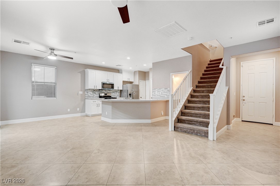 645 Monument Point Street Henderson, NV 89002 - Photo 54 of 54 Kitchen with open floor plan, tasteful backsplash, a ceiling fan, white cabinets, and recessed lighting