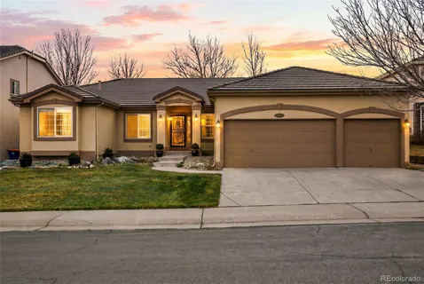 a front view of a house with a garden and garage