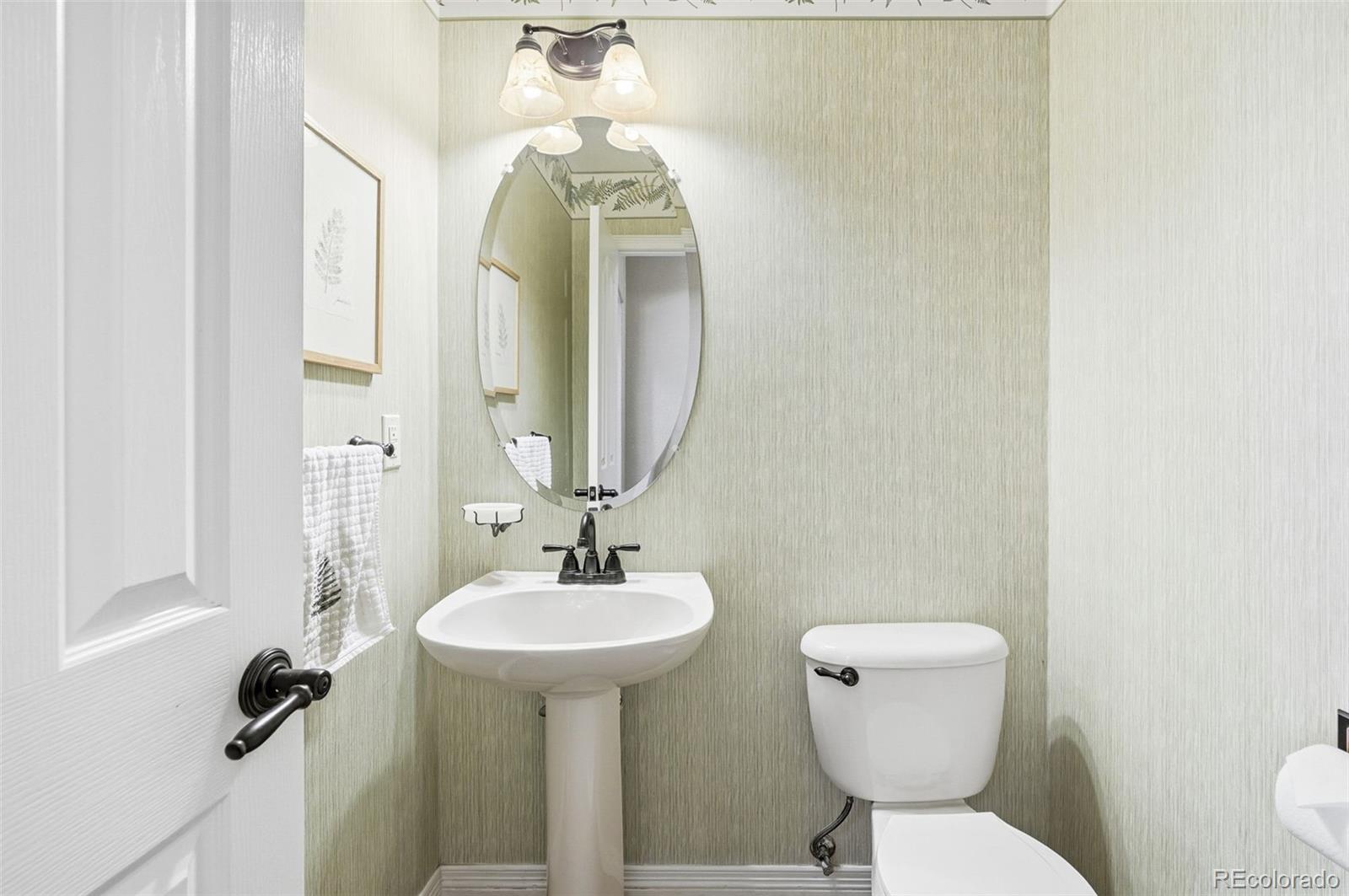 10482 Grizzly Gulch Highlands Ranch, CO 80129 - Photo 19 of 50 a bathroom with a toilet sink and mirror