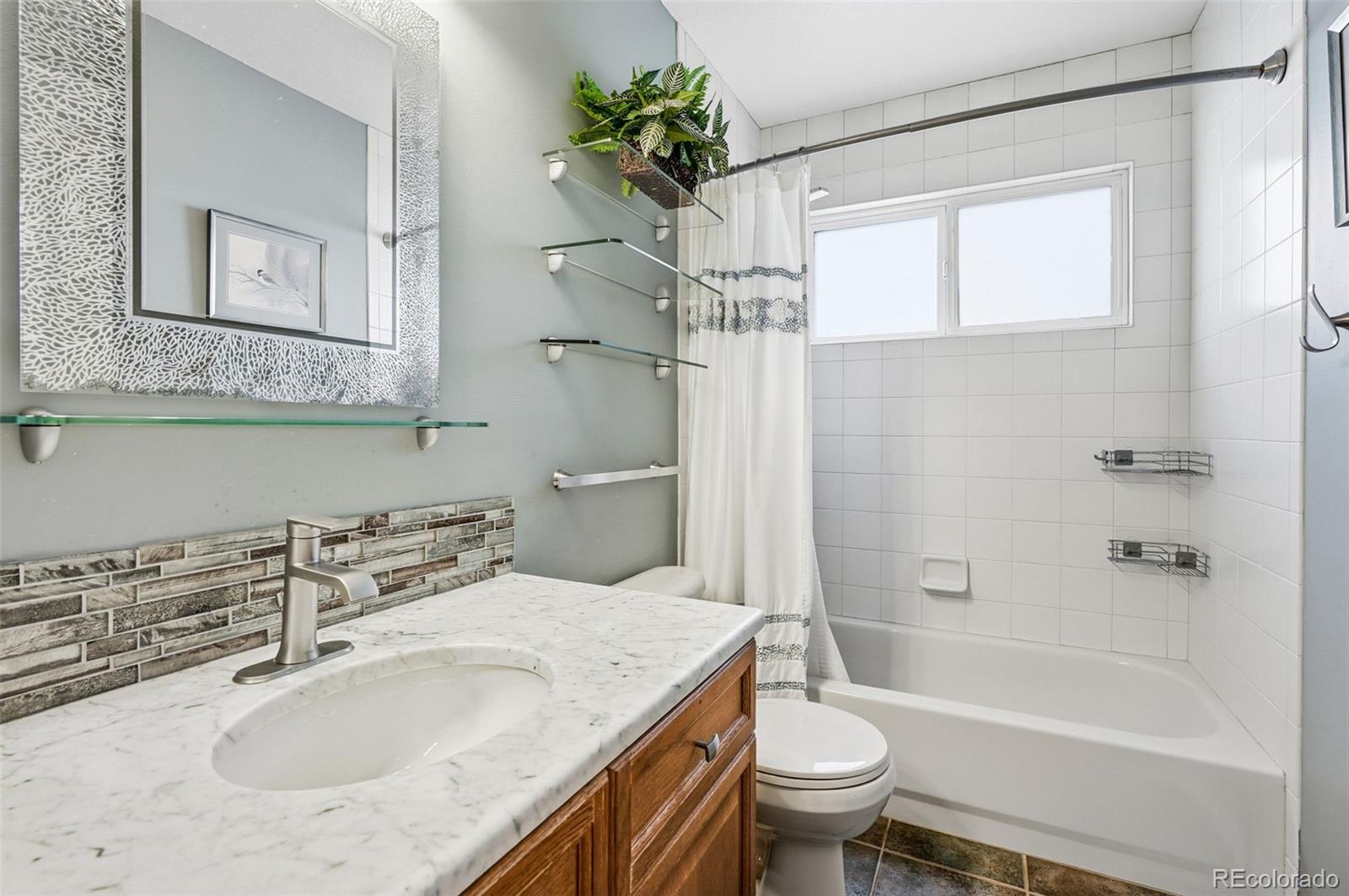 10482 Grizzly Gulch Highlands Ranch, CO 80129 - Photo 37 of 50 a bathroom with a granite countertop sink a toilet and shower