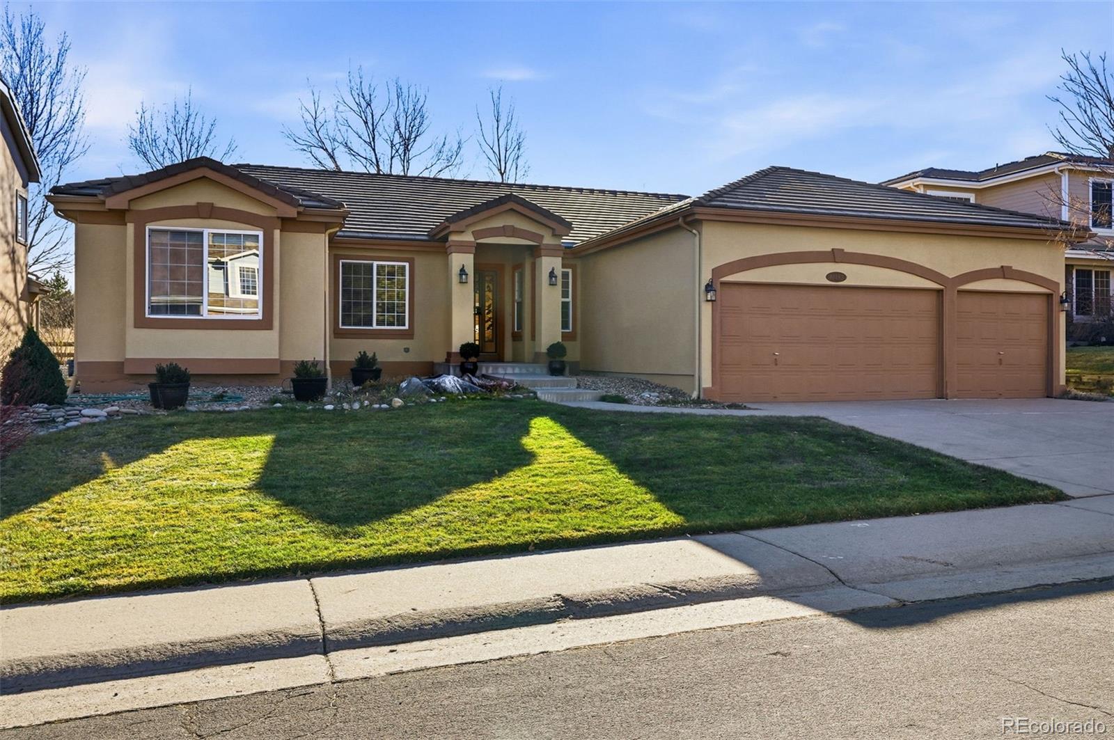 10482 Grizzly Gulch Highlands Ranch, CO 80129 - Photo 44 of 50 a front view of a house with a yard and garage