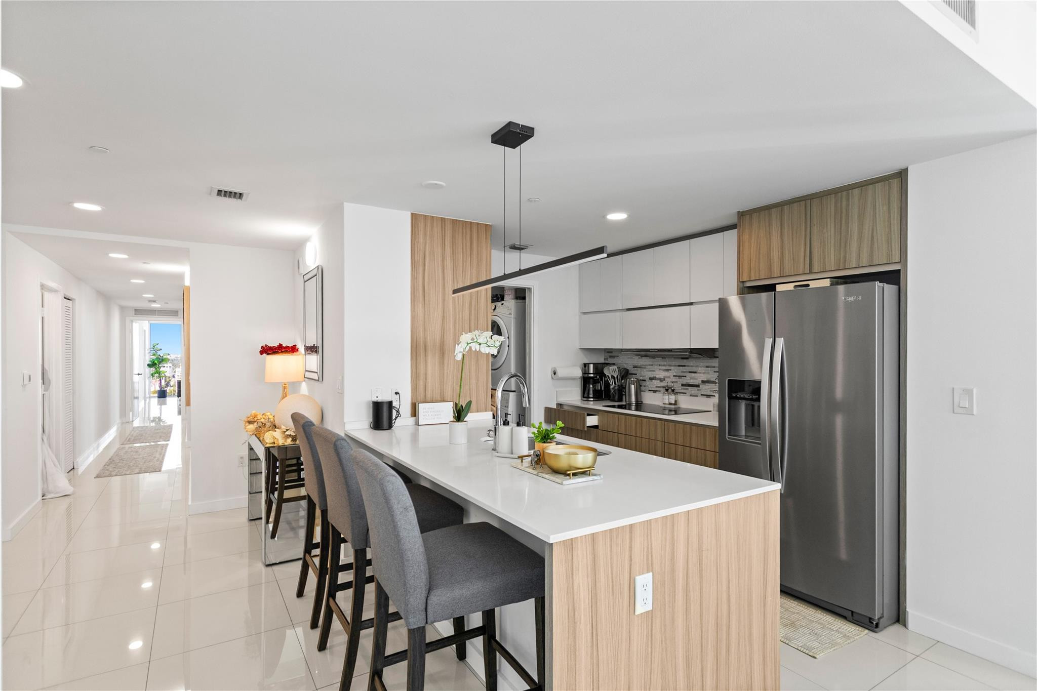 600 Northeast 27th Street, Unit 2301 Miami, FL 33137 - Photo 16 of 77 a kitchen with kitchen island a refrigerator a table and chairs