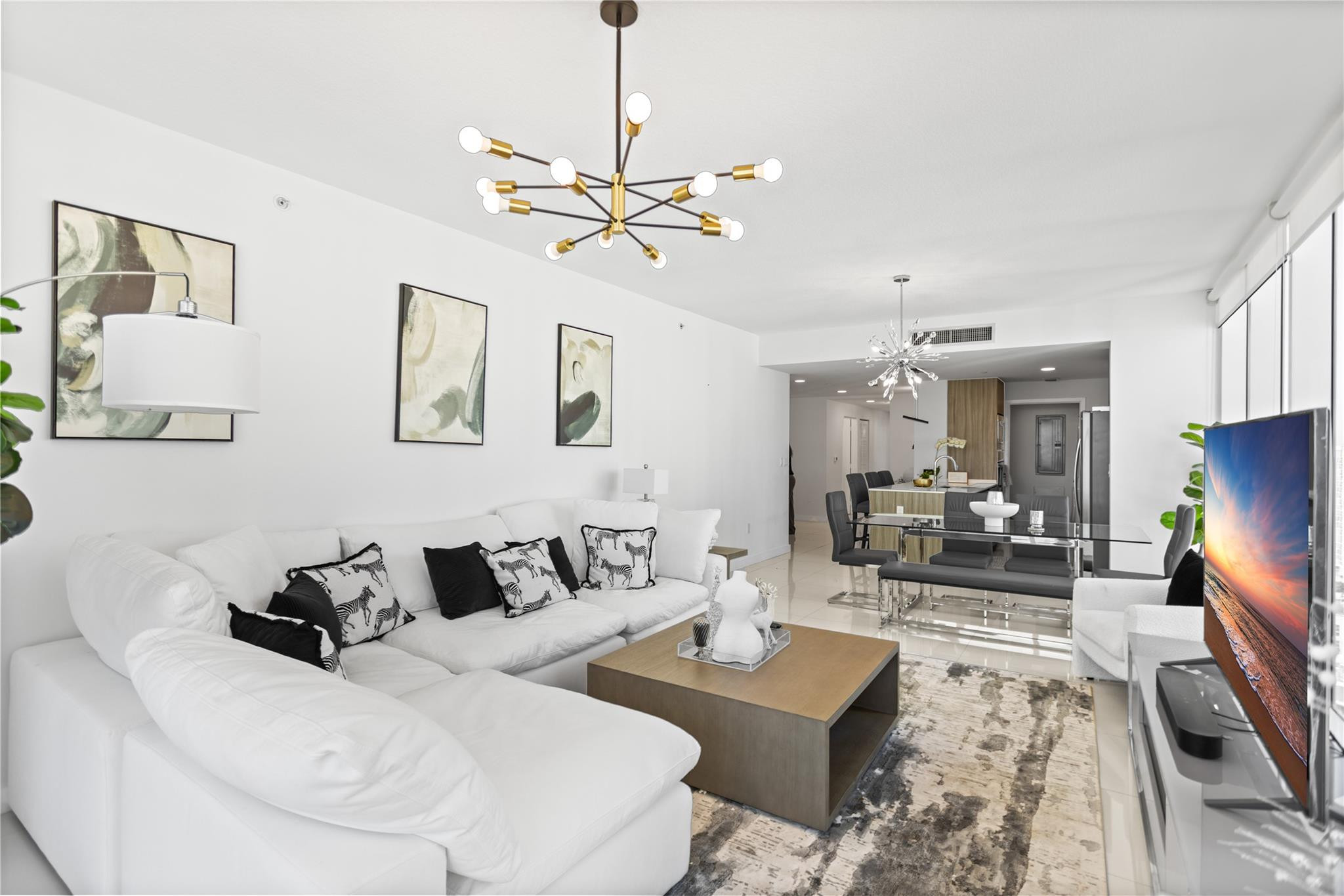 600 Northeast 27th Street, Unit 2301 Miami, FL 33137 - Photo 60 of 77 a living room with furniture a chandelier and a flat screen tv