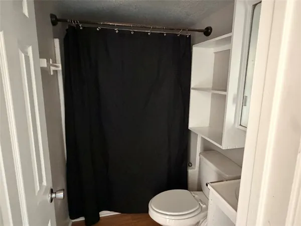 a bathroom with a shower toilet and sink