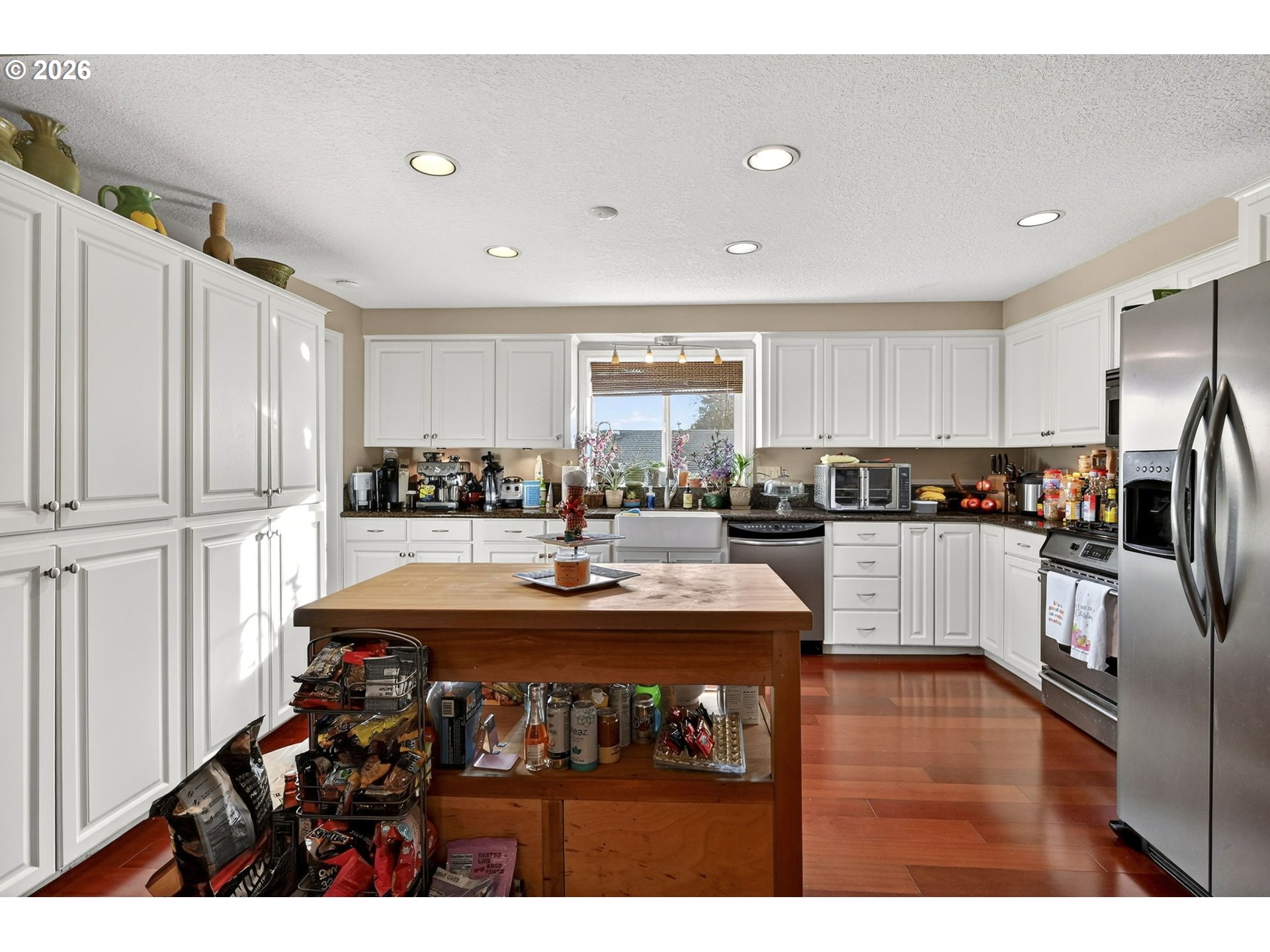 2445 Debok Road West Linn, OR 97068 - Photo 14 of 45 a kitchen with stainless steel appliances granite countertop a refrigerator a sink a stove and white cabinets with wooden floor