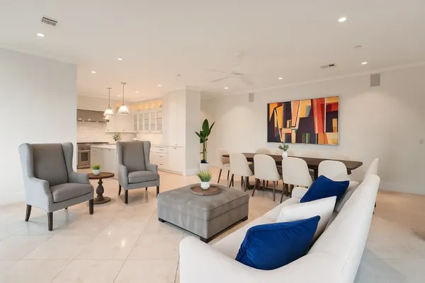 a living room with furniture kitchen view and a wooden floor