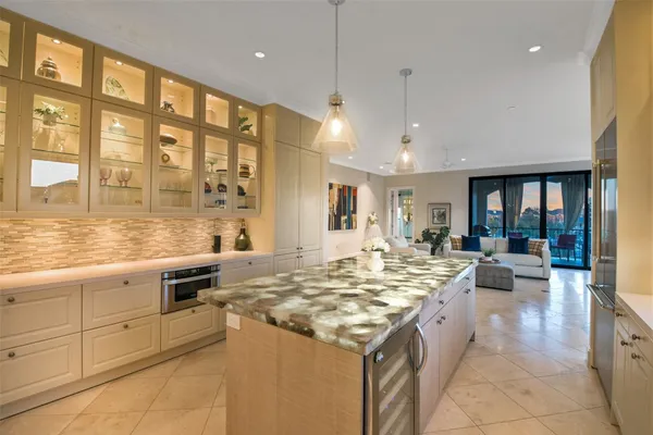 a large kitchen with kitchen island a counter space a sink a stove and cabinets