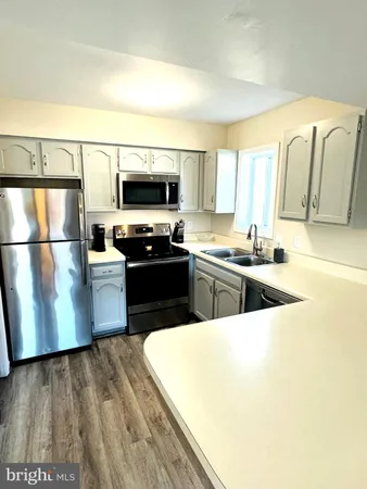 a kitchen with stainless steel appliances a stove a sink and a refrigerator
