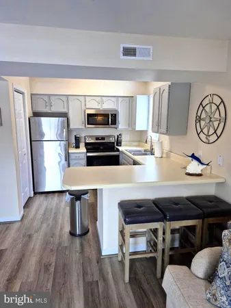 a kitchen with a table chairs in it and wooden floors