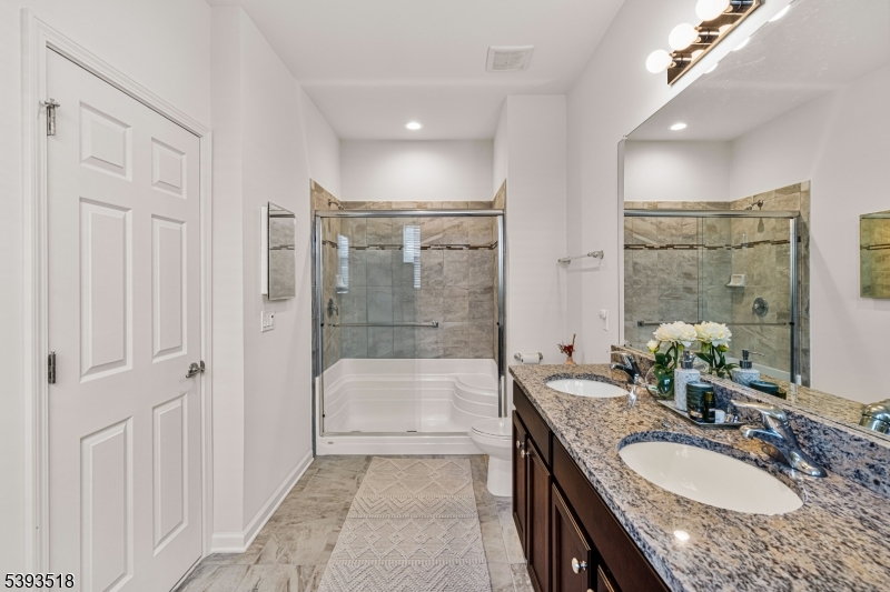 15 Potter Road Hillsborough, NJ 08844 - Photo 21 of 29 a bathroom with a granite countertop sink a mirror a bathtub and shower