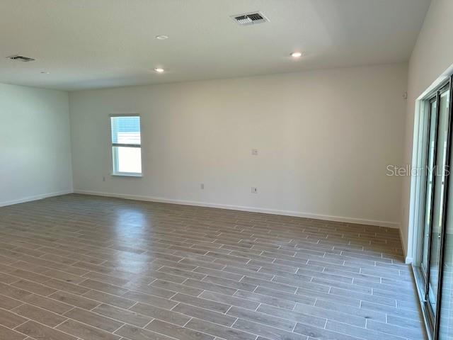 4511 Northwest 14th Loop Ocala, FL 34482 - Photo 16 of 27 an empty room with wooden floor and windows