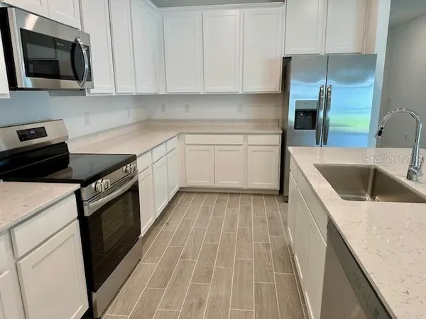 a kitchen with a sink stove and microwave