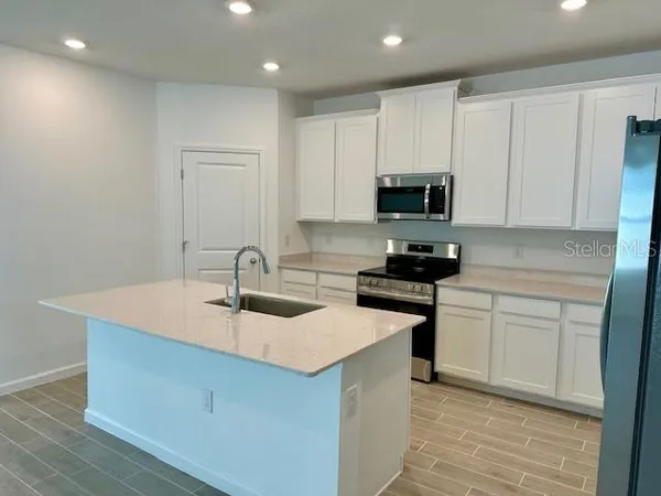 a kitchen with stainless steel appliances granite countertop a sink stove and cabinets