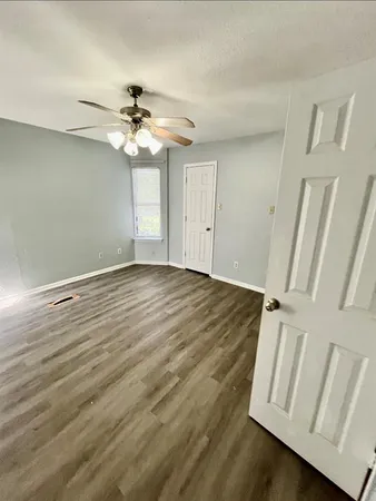 an empty room with windows and fan