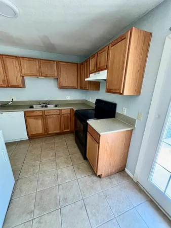 a kitchen with stainless steel appliances a stove a sink a counter top space and cabinets