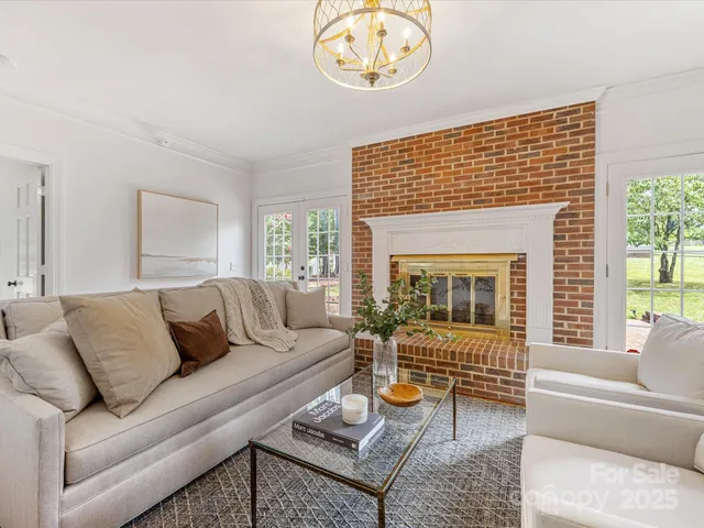 a living room with furniture a flat screen tv and a floor to ceiling window
