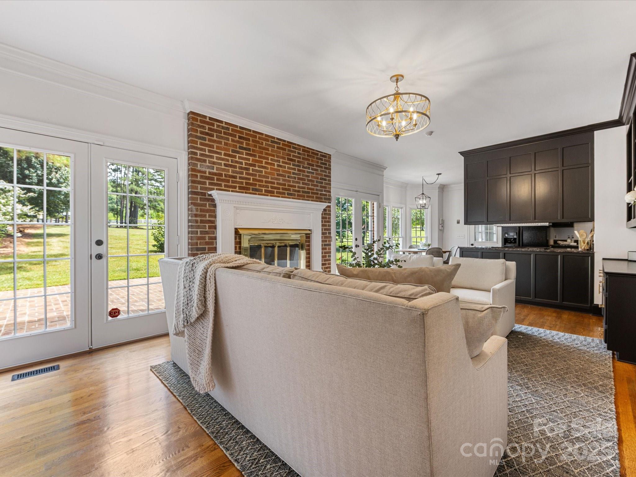 11215 Idlewild Road Matthews, NC 28105 - Photo 30 of 48 a living room with furniture a flat screen tv and a floor to ceiling window
