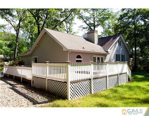 5 Beech Lane Edison, NJ 08820 - Photo 17 of 25 a view of a white house that has a small yard and large trees