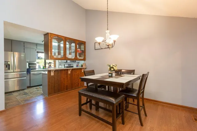 a view of a dining room with furniture a chandelier and wooden floor