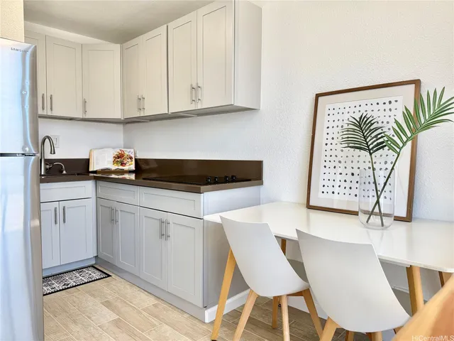 a kitchen with granite countertop white cabinets and white appliances